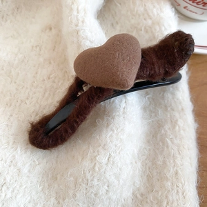 Detailed macro view of heart-shaped wool hair clip with soft plush texture and metal base
