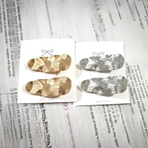 Set of four minimalist brushed gold and silver wavy alloy hair clips on white card base