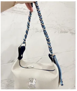 Detail of colorful hand-woven braided rope strap on an ivory canvas bucket bag