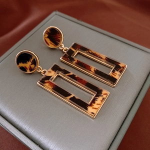 Close-up of tortoiseshell acrylic earrings with gold metal trim on jewelry box