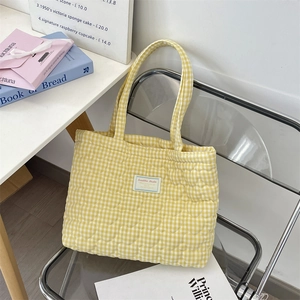 Détail du sac cabas matelassé à carreaux jaunes avec motif de cœurs brodés