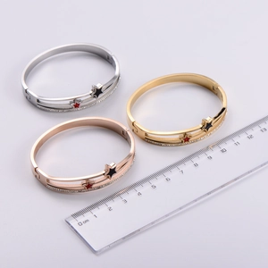 Close-up of three star-shaped bracelets in silver, gold, and rose gold with zircon inlay