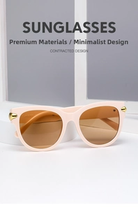 Detail view of pink oval sunglasses featuring gold rivet accents on white pedestals
