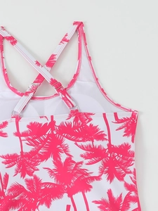 Close-up of pink palm tree print tankini with criss-cross straps and metal adjusters