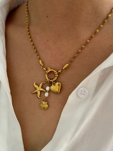 French design gold starfish and pearl pendant necklace on a model wearing white shirt
