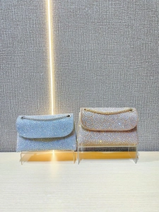 Sparkling crystal evening bags in blue and gold with ripple pattern on display