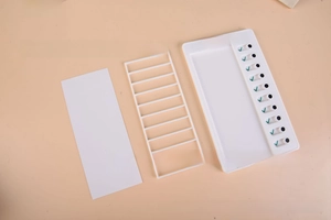 Disassembled view of white ABS To Do List board with slider switches and paper insert
