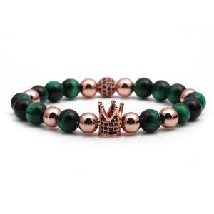 Detail of beaded bracelet with rose gold crown charm, tiger eye and matte black stones
