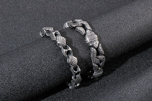 Close-up of men's vintage geometric steel bracelets with embossed grid texture