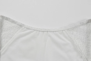 Close-up of a white round neck top featuring delicate chiffon fabric and floral lace sleeves