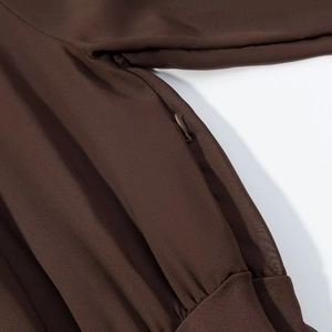 Détail d'une robe marron foncé avec fermeture éclair invisible et texture de tissu fine
