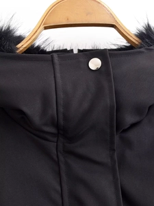 Close-up of black hooded jacket collar featuring silver metal button and faux fur trim