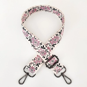 Detail of adjustable floral strap with pink flowers and dark grey metal hooks