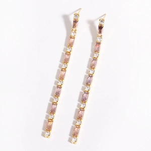 Detailed view of long 18K gold plated drop earrings with pink and white cubic zirconia