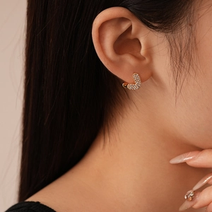Elegant gold plated heart hoop earrings with pavé set cubic zirconia on model