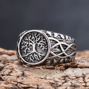 Macro shot of Viking tree of life ring with Celtic knot patterns on vintage bark texture