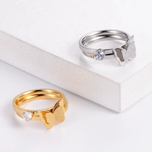 Luxurious butterfly rings in gold and silver with cubic zirconia on stone background