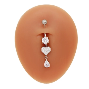 Détail du piercing de nombril cœur en argent avec zircone claire sur modèle en silicone