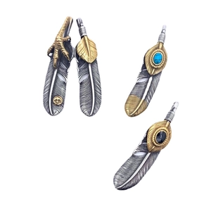 Vintage titanium steel feather pendants with turquoise and eagle claw details on white background