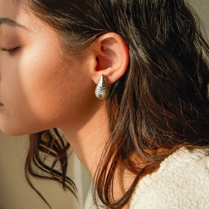 Detailed view of silver stainless steel water drop earrings with striped shell texture