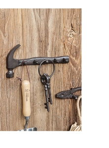 Detail of vintage cast iron hammer and plier hooks with rustic texture on wood
