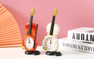 Dettaglio di sveglie creative a forma di violino in bianco e marrone rossastro per bimbi
