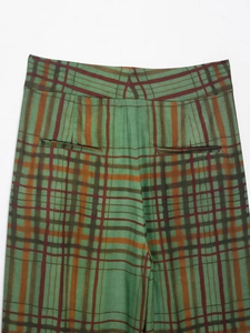 Détail de poche arrière et texture tissée sur ce pantalon à carreaux vert