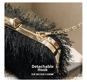 Close-up of detachable gold chain hook on a black feather evening clutch bag