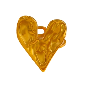 Detail shot of golden heart ring with irregular lava texture and metallic finish
