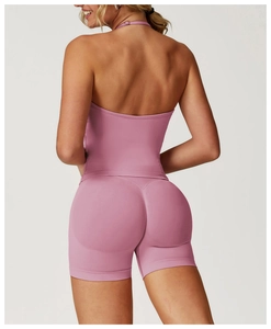 Rear view of pink seamless yoga set featuring halter back top and shaping sports shorts