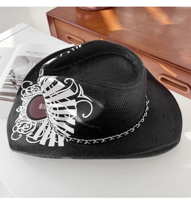 Détail d'un chapeau de cowboy noir avec imprimé tribal et chaîne métallique décorative