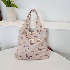 Detailed close-up of pink jacquard fabric with butterfly patterns on a shoulder bag