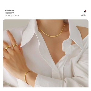 Dettaglio del set collana a catena a serpente e anelli placcati in oro 18 carats da donna