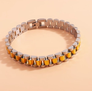 Close-up of dual-tone gold and silver stainless steel watch strap style bracelet