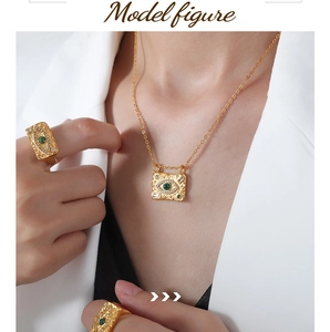 Close-up of gold 18k evil eye pendant necklace and matching rings on a female model