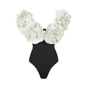 Detail of 3D white floral applique on a contrast black one-piece swimsuit bodice