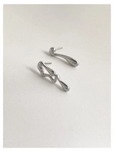 Detail view of silver asymmetrical liquid metal stud earrings with high polished finish