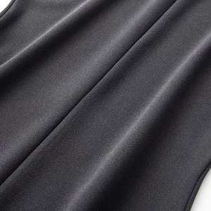 Close-up of high-quality dark grey crepe fabric texture with elegant ruffled edge details