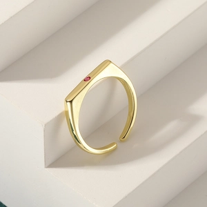 Minimalist gold square ring with red zircon stone on white geometric background