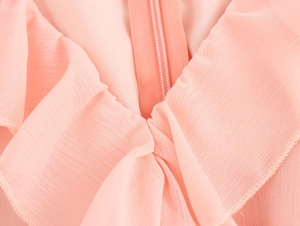 Close-up of elegant pink dress showing ruffle neckline and hidden zipper detail