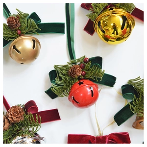 Detailed view of Christmas bell ornaments with velvet bows, pine cones and needles