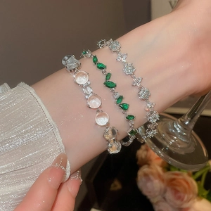 Détail de bracelets fleurs en zircon avec pierres vert émeraude et pierre de lune