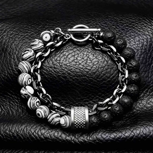 Detail of beaded men's bracelet with map stone and lava rock on black leather background