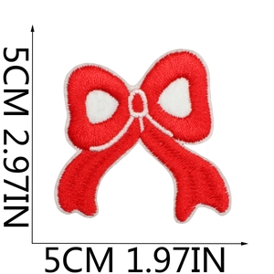 Detail view of 5x5cm red embroidered bow patch with white stitched edges for clothing