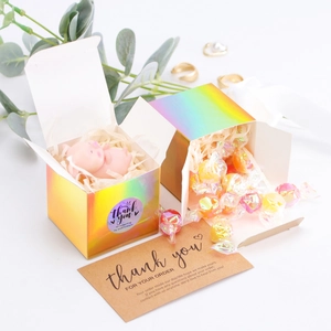 Detailed view of holographic cube gift box with thank you stickers and tissue filler