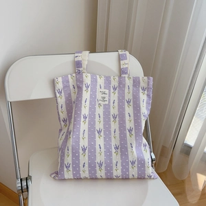 Purple floral cotton tote bag with lavender patterns on white folding chair