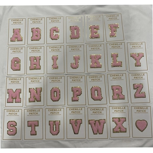 Close-up of pink chenille alphabet patches with gold glitter and self-adhesive backing
