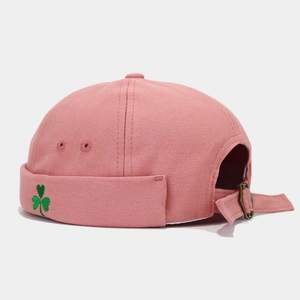 Close-up of pink cotton miki hat featuring green clover embroidery and adjustable strap