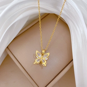 Macro shot of gold hollow butterfly pendant with zircons in a premium jewelry gift box