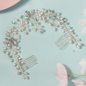 Close-up of bridal hair comb with pearls and rhinestones on a light blue background